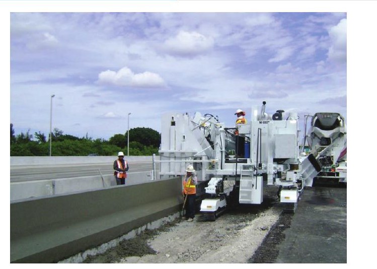 Miller Formless M-8800 slipforming a tall highway safety barrier wall